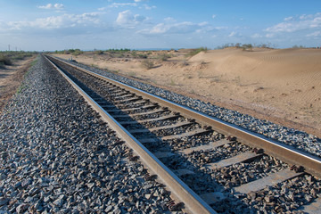 Railroad (railway) going through the desert. Kyzylkum desert, Uzbekistan, Central Asia.