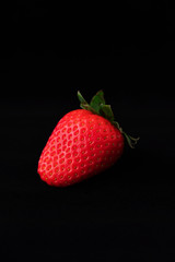 Strawberry with strawberry leaf on black background
