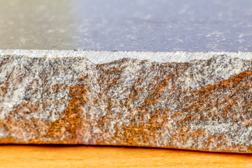 a piece of granite lies on the table. Sectional photo. Close-up.