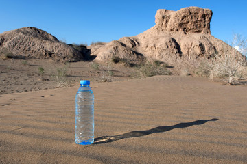 Bottle of water on the sand of desert. Kyzylkum desert, Uzbekistan, Central Asia.