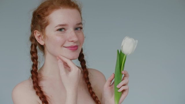 Natural beauty, spring, face skin care concept. Young happy smiling redhead woman with freckles touches her cheek. Close up portrait. Copy, empty space for text
