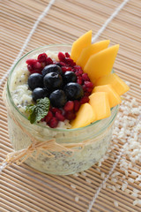 Chia Milchreis im Glas mit Bastschleife, angerichtet mit mango, blaubeeren, granatapfelkernen und...