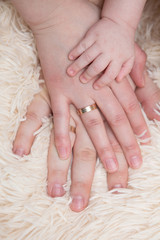 Hands of a newborn baby dad and mom