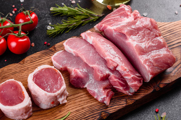 Fresh pieces pork ready to cook on a dark background in the kitchen