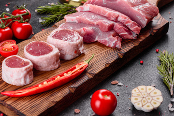 Fresh pieces pork ready to cook on a dark background in the kitchen