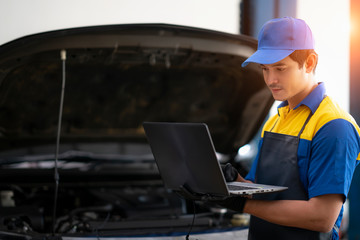Car repair technicians use laptop computers to measure engine values for analysis
