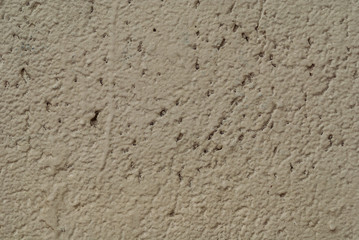 Stone surface beige colored with mottled texture. painted wall texture with unpainted recesses