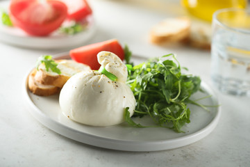 Italian cheese salad with tomatoes and arugula