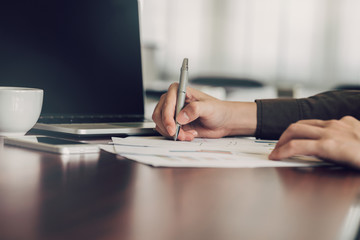 business man hand writing note paper on wooden table