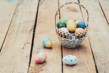 colourful easter egg and basket on wood background