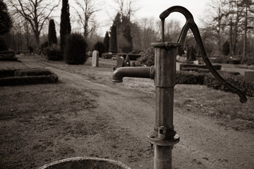 old cast-iron water pump stands on a cemetery