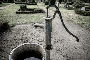 old cast-iron water pump stands on a cemetery