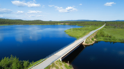 Aerial view of the bridge and the road over the River. Sunny summer day. Blue sky with clouds. Finland