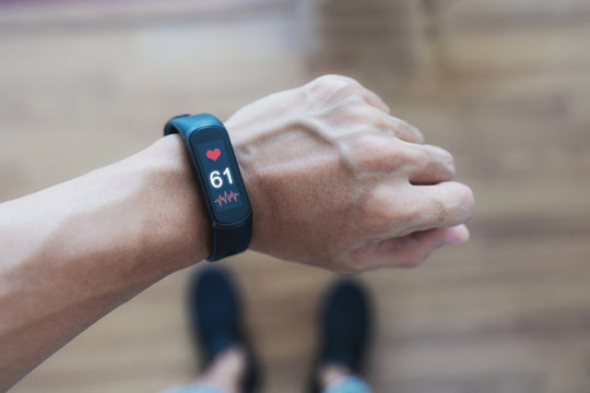 Smart Fitness Tracking And Watch. A Man Using Smart Band Tracking Heart Rate And Health Data