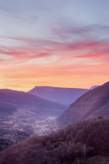 Obraz premium Burning sky before sunset above valley of Dojkinci village on the Old mountain, Serbia and curvy mountain road