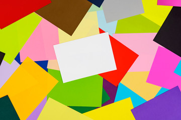 A multi-colored kaleidoscope of colored sheets of paper scattered chaotically in the style of ruled, beautiful chaos on a colorful background with a white sheet for notes.