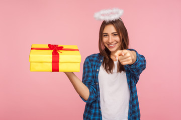 Gift from angel for you! Portrait of generous beautiful girl with halo over head pointing to camera...