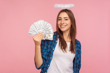 Portrait of lottery winner, lucky angelic girl with halo over head showing money, holding dollar...