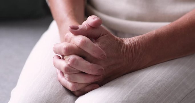 Close up view of senior female hands clasped. Retired lonely woman praying with hope feels anxiety and solitude. Older adult single grandmother pensioner worries about elder health care problem