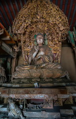 Ancient statue of buddha in ancient altar with carved details in wood. Altar figure located in Shuanglin Temple (or Zhongdu Temple), outskirts Pingyao Old City, Shanxi province, China