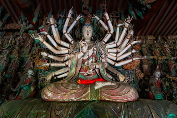 Fine ancient figure of buddhist goddess with 24 arms.  Altar statue made in wood located in Shuanglin Temple (or Zhongdu Temple), outskirts Pingyao Old City, Shanxi province, China