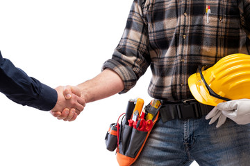 Close-up of a handshake of the electrician carpenter holding helmet and protective goggles in hand....