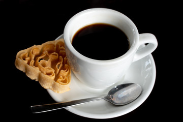 A Cup of Coffee and a Biscuit on a Blcak Background