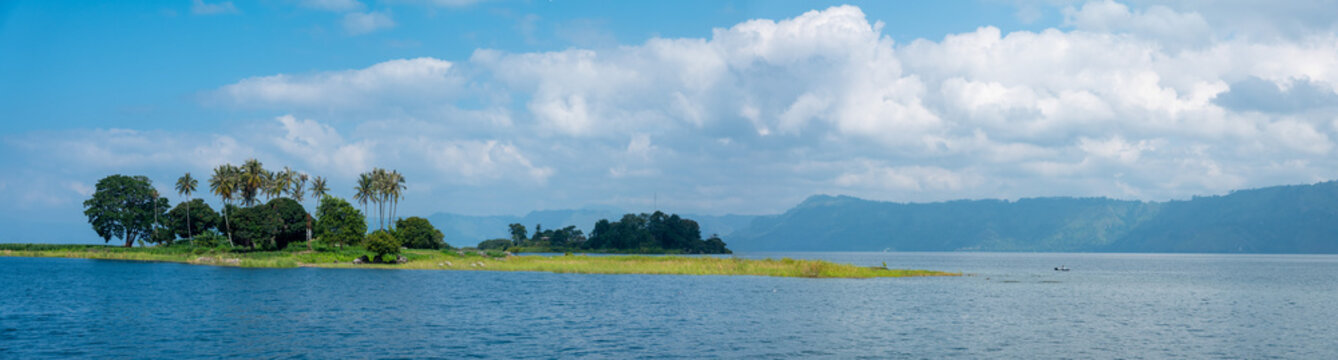 A Beautiful Green Island in the Beautiful Blue Tropical Waters of Lake Toba in Indonesia