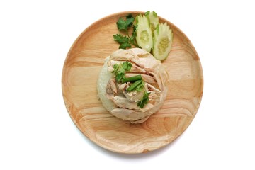 Obraz na płótnie Canvas Top eye view closeups of Hainanese chicken rice or rice steamed with chicken soup Thai gourmet and slide cucumber in the soft wooden plate isolated on a white table background at a kitchen room