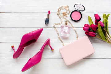 Fashion bag and shoe woman accessories background. Trendy fashion luxury handbag, heels  shoe, perfume and cosmetic design with pink tulip flower. Lifestyle and Beauty Concept