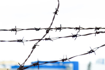 barbed wire, blue building on the background