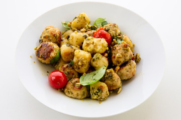 Gnocchi and chicken meatballs with pesto sauce, basil, tomatoes and nuts