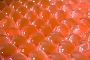 Red hydrogel balls. Bright round gel. Science. Caviar. Transparent water texture. Fresh colorful background. Macro