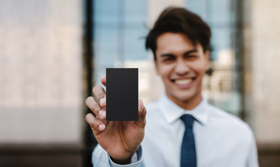 Business Card Mockup Image. Happy Young Businessman Presenting a Black Blank Paper Card with Clipping Path