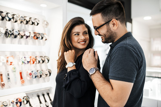Middle age couple enjoying in shopping at modern jewelry store. Close up shot of human hand holding expensive watch.