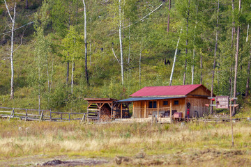 Beautiful landscape. Zeya reservoir, Amur region. View from the sea to the wooden buildings of the Zeya nature reserve cordon against the backdrop of green forests and hills.