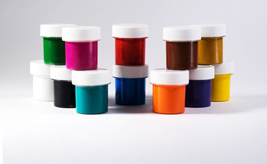 Multi-colored gouache in plastic jars on a white background to create beautiful paintings