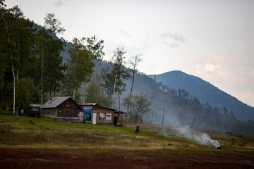 Beautiful landscape. Zeya reservoir, Amur region. View from the sea to the wooden buildings of the Zeya nature reserve cordon against the backdrop of green forests and hills.