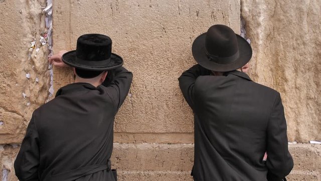 Two orthodox hasidic Jews praying at Wailing Wall in Jerusalem ( Kotel or the Western Wall of Jerusalem. )