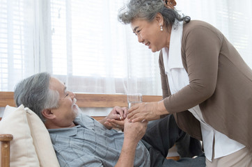 elder man take pills while elder woman take care.