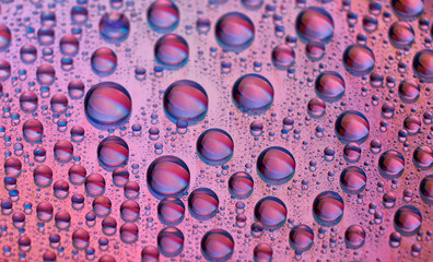 Close-up of water drops on an illuminated compact disc