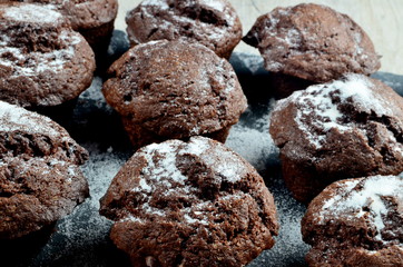 chocolate muffins on black stone plate and gray wood background, place for text