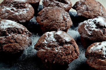chocolate muffins on black stone plate and gray wood background, place for text