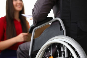 Close-up view of smiling businesswoman interviewing disabled candidate in office. Male in disabled...