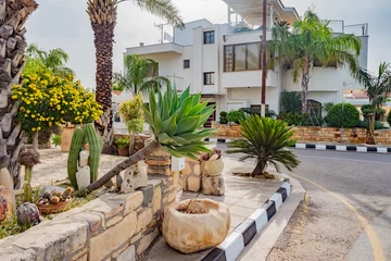  Cyprus. Kuklia. Aphrodite's Rock. Petra tou Romiou. The street of the resort. Plants on the streets. Palm trees and cacti. Flora. The Landscape Of The Mediterranean. Residential house in Cyprus. © Grispb
