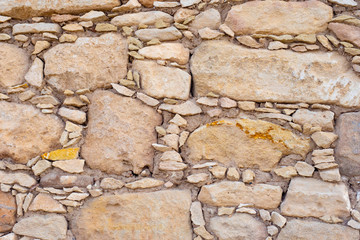 Background of stone. The stone wall is beige. Natural stone. Beige background. Construction. Old wall. Background fragments of different sizes and shapes.