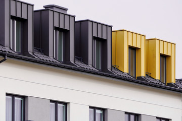 Facade of windows in attic or loft housing or office. Apartments under the roof in a modern house or cottage. Close-up of modern construction