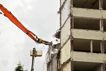 crane lift works on demolition of brutal reinforced concrete plate build biulding