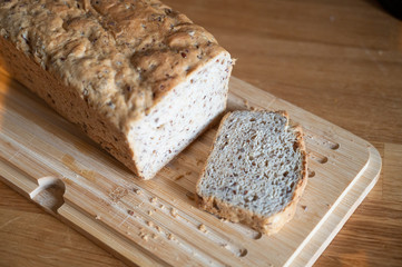 frisches brot wurde angeschnitten eine scheibe brot liegt daneben auf einem holz brett