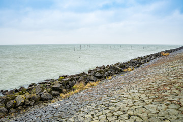 Fototapeta na wymiar Stony embankment by the coast of Markermeer near Almere in Netherlands
